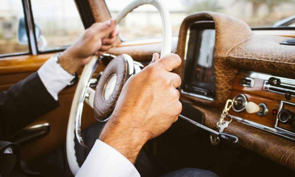 person holding vehicle steering wheel