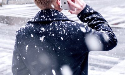 man holding iPhone over ear
