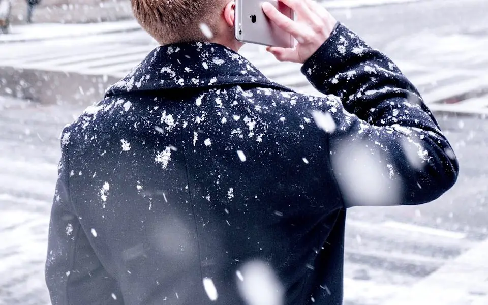 man holding iPhone over ear