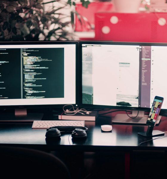 two black computer monitors on black table