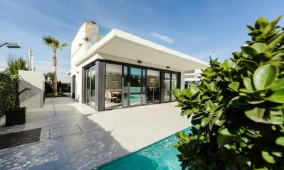 white and grey concrete building near swimming pool under clear sky during daytime