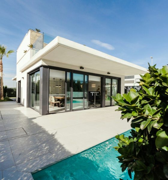 white and grey concrete building near swimming pool under clear sky during daytime